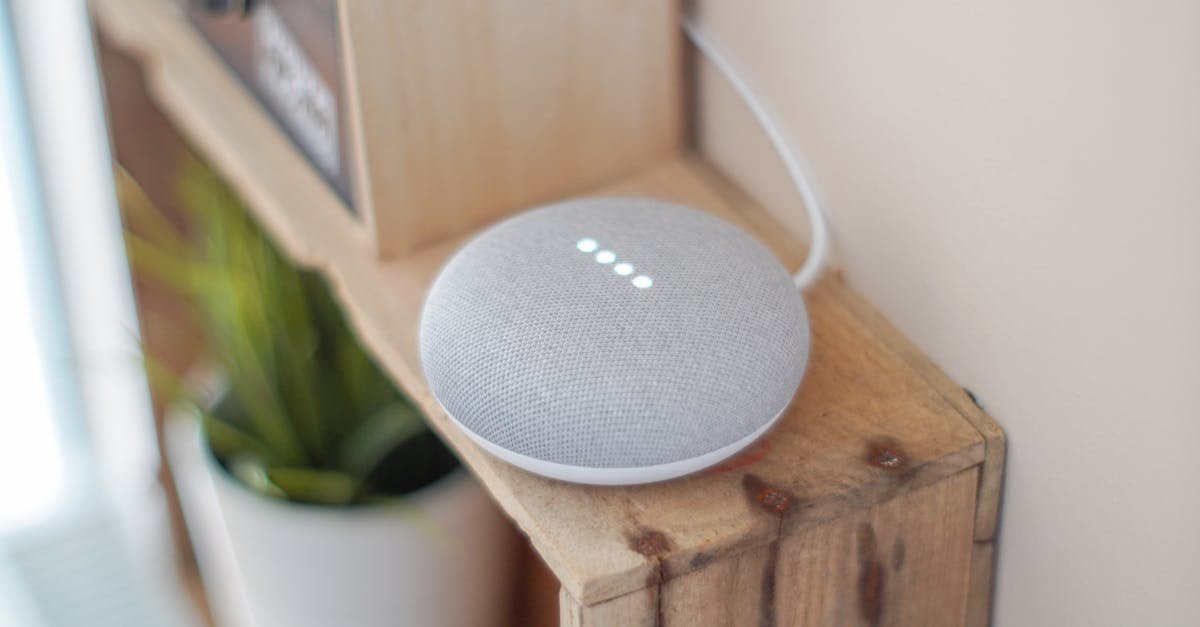A Google Home Mini smart speaker on a wooden shelf, blending technology with home decor.
